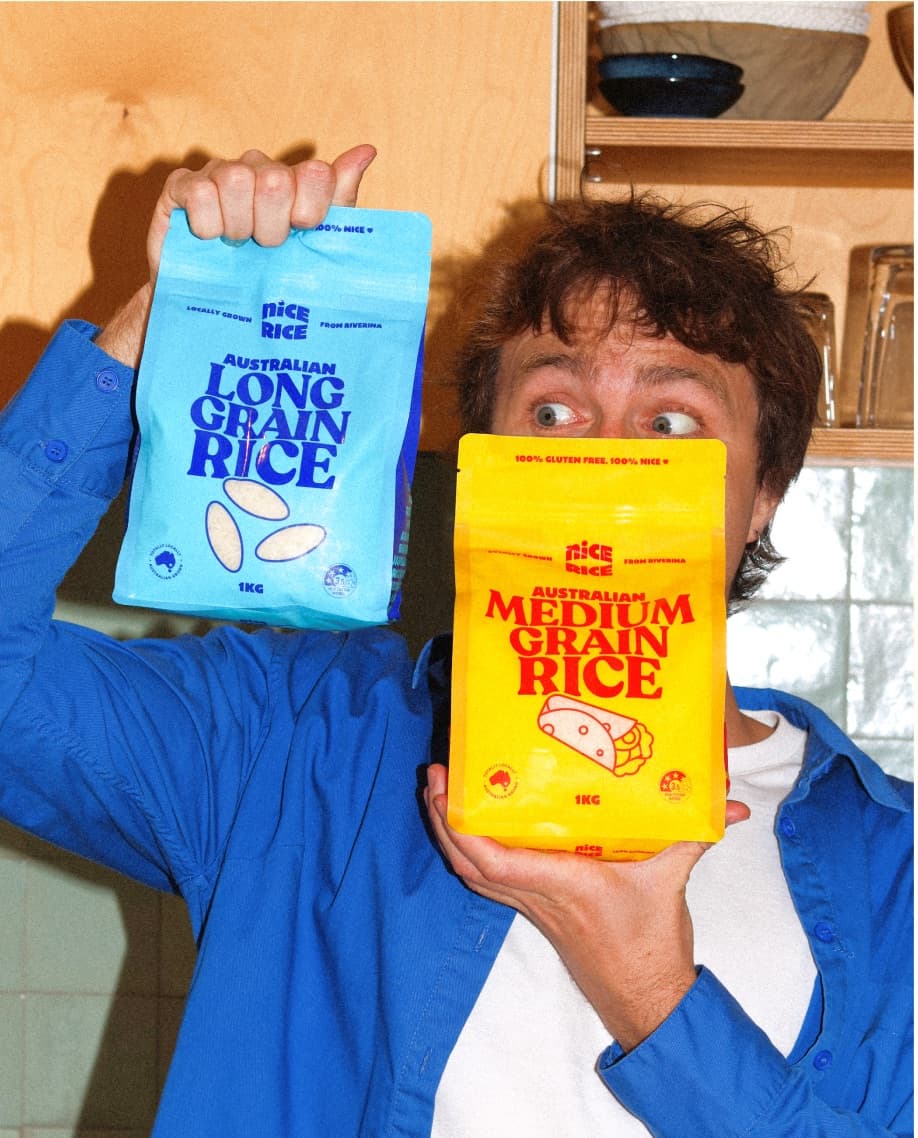 Person holding Nice Rice grocery bags in a kitchen