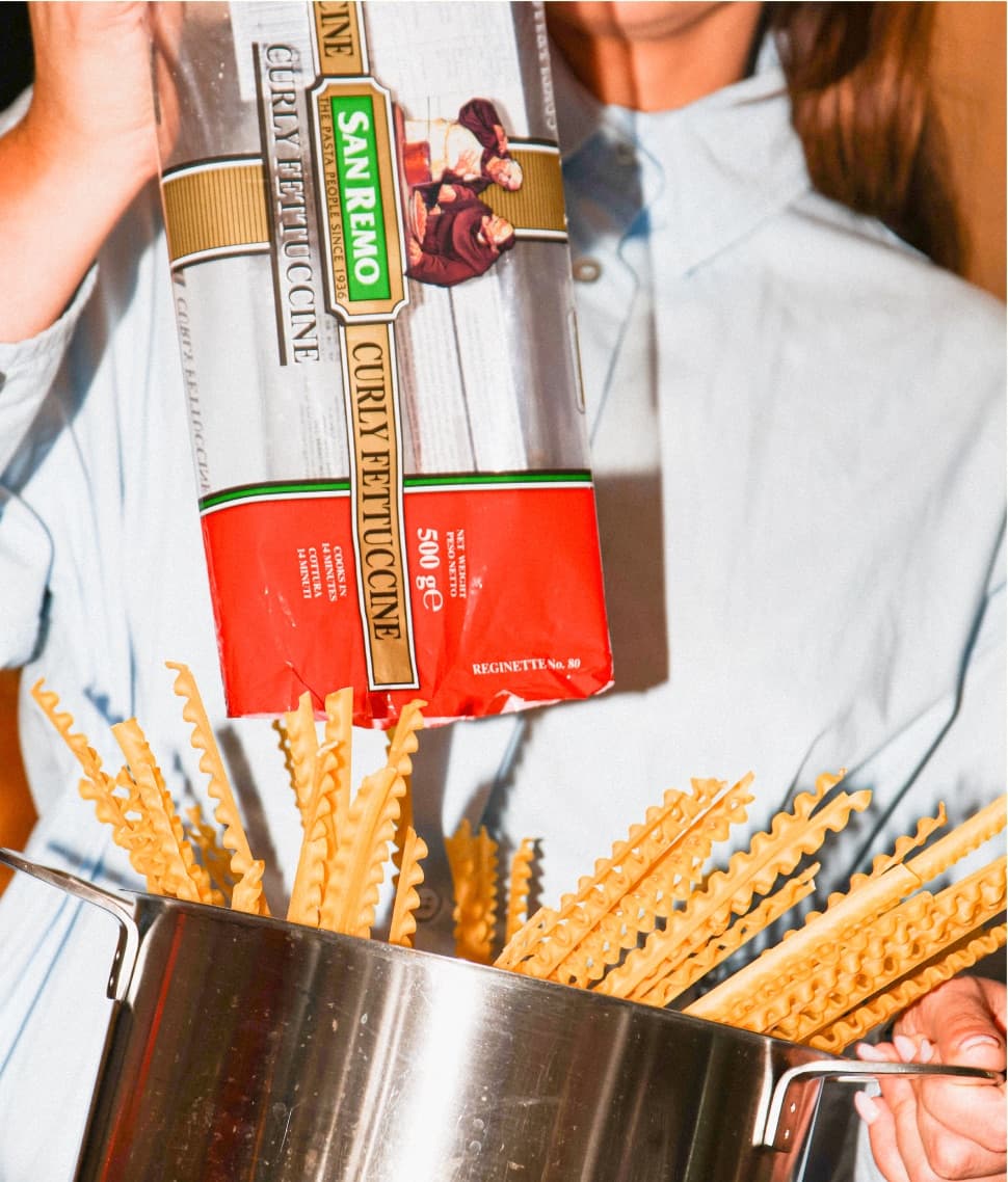 Person holding San Remo pasta above a pot of pasta